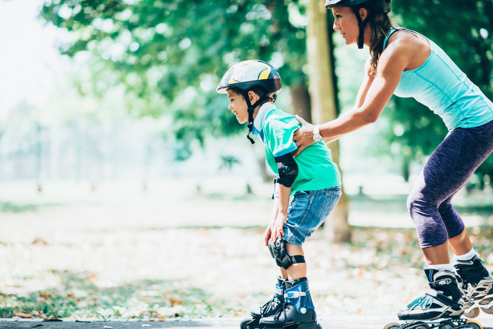 Vrouw helpt kind met balans houden bij het skaten